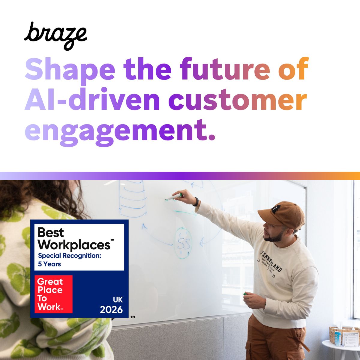 Person writing on a whiteboard next to a Great Place to Work badge and a headline about AI driven engagement